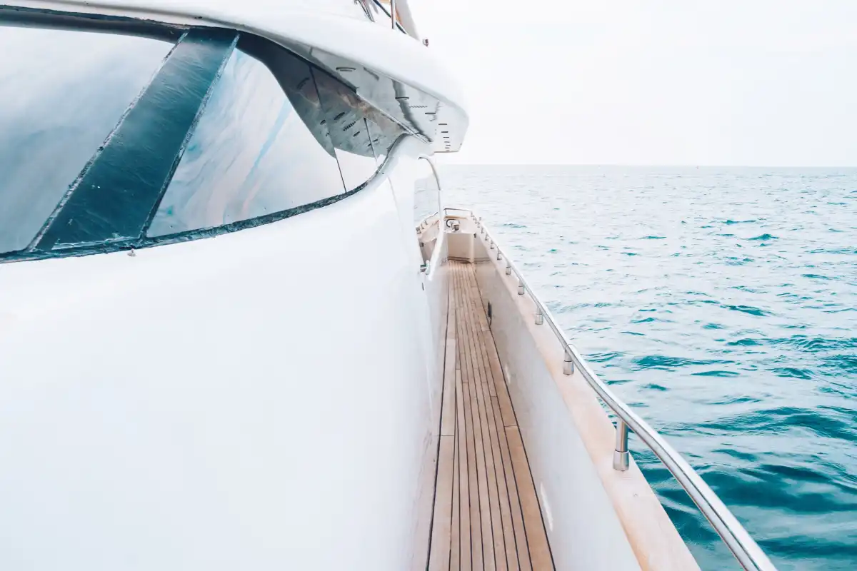 smiling-man-lying-on-deck-of-his-motor-yacht-using-2023-11-27-05-02-25-utc